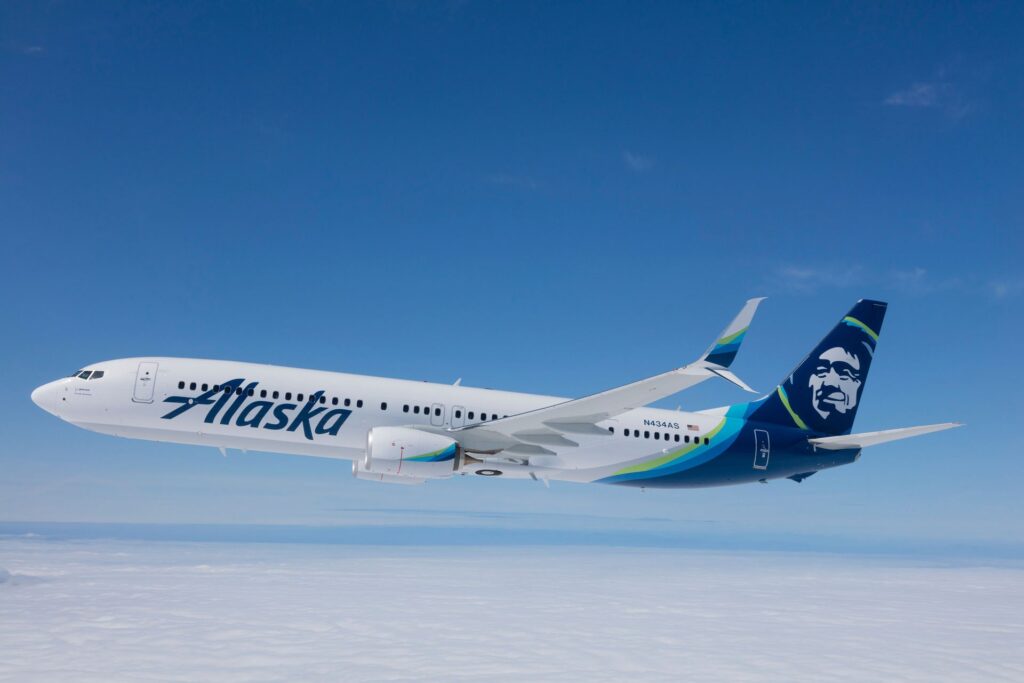 Alaska Airlines 737 flying through a clear blue sky