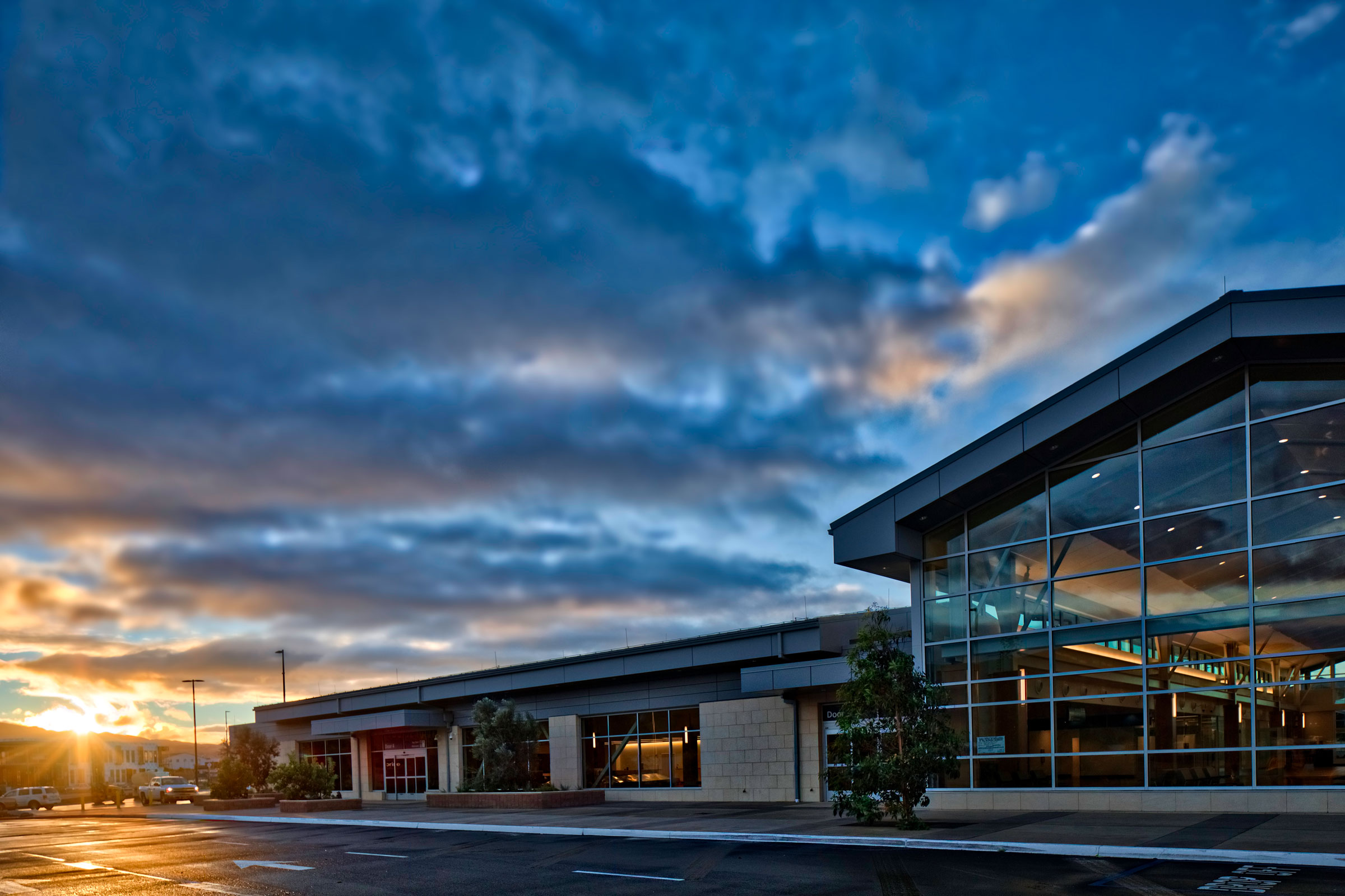 Curbside view of the SBP airport terminal at sunset