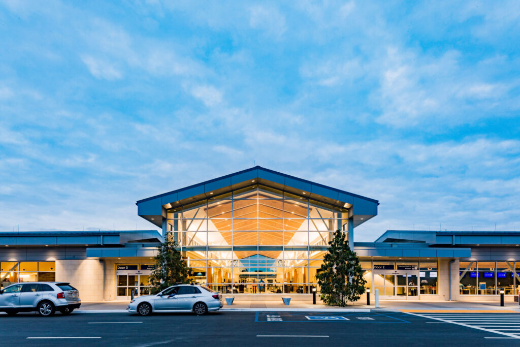 The front of the SLO Airport Terminal shining bright at dusk